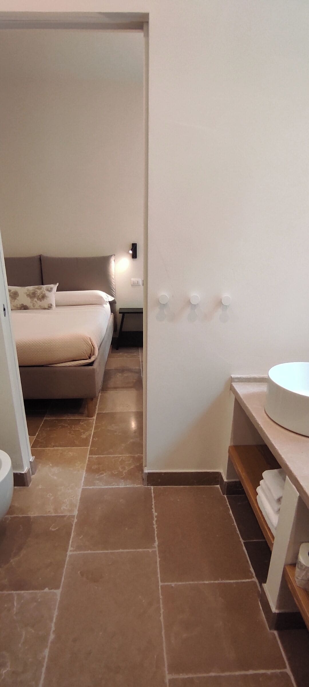 Ein Schlafzimmer mit einem Bett, einem Nachttisch und einer Wandleuchte.