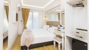 Une chambre d’hôtel avec un grand lit, une table de chevet et un mini-réfrigérateur intégré.