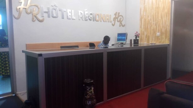 Taulell de recepció d'hotel amb disseny de panell de fusta i un monitor informàtic.