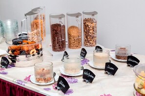 Freshly prepared snacks and treats are arranged on a table, offering a variety of grains, nuts, and dried fruits.
