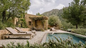 A poolside area with lounge chairs and a stone building with vines. - Es Racó d’Artà, a Member of Design Hotels™ (Arta)