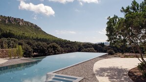 A swimming pool with a clear view of a mountainous landscape in the background. - Es Racó d’Artà, a Member of Design Hotels™ (Arta)