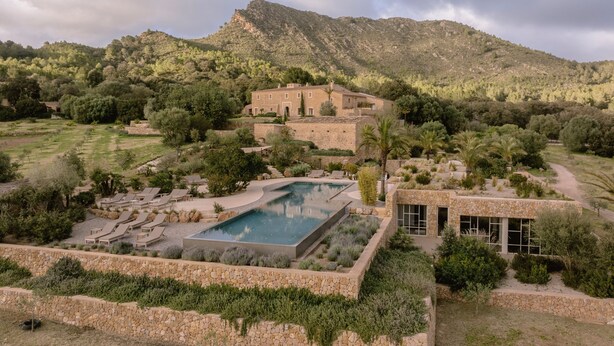 A resort with a swimming pool, lounge chairs, and a mountain backdrop. - Es Racó d’Artà, a Member of Design Hotels™ (Arta)