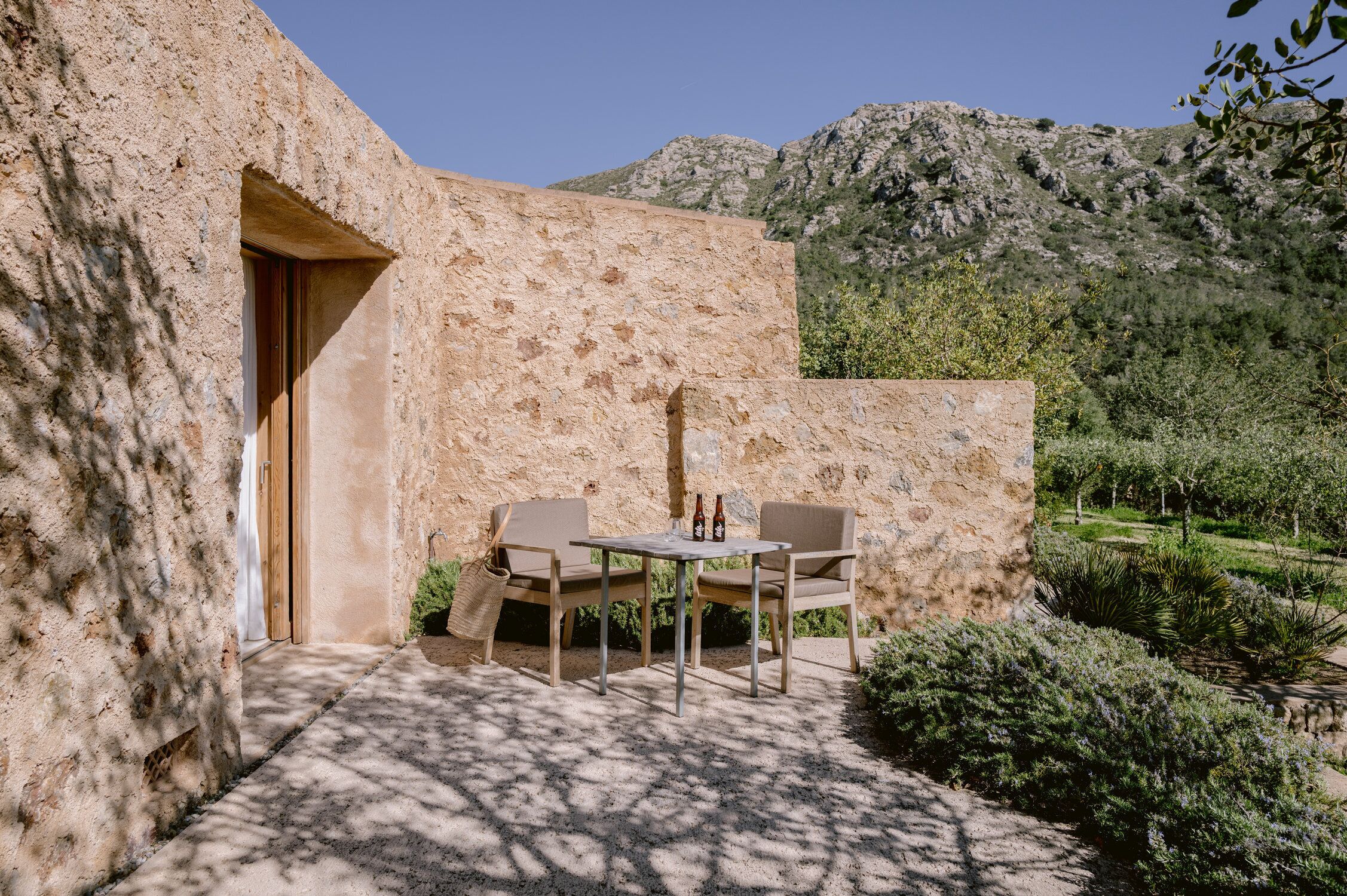 Un espace extérieur aménagé avec une table et des chaises, une porte et une vue sur un paysage montagneux.