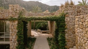 Un sendero de piedra que lleva a un área de descanso cubierta con vistas a las montañas.