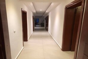 Stylish hallway leading to a room with a tiled floor and wooden doors.
