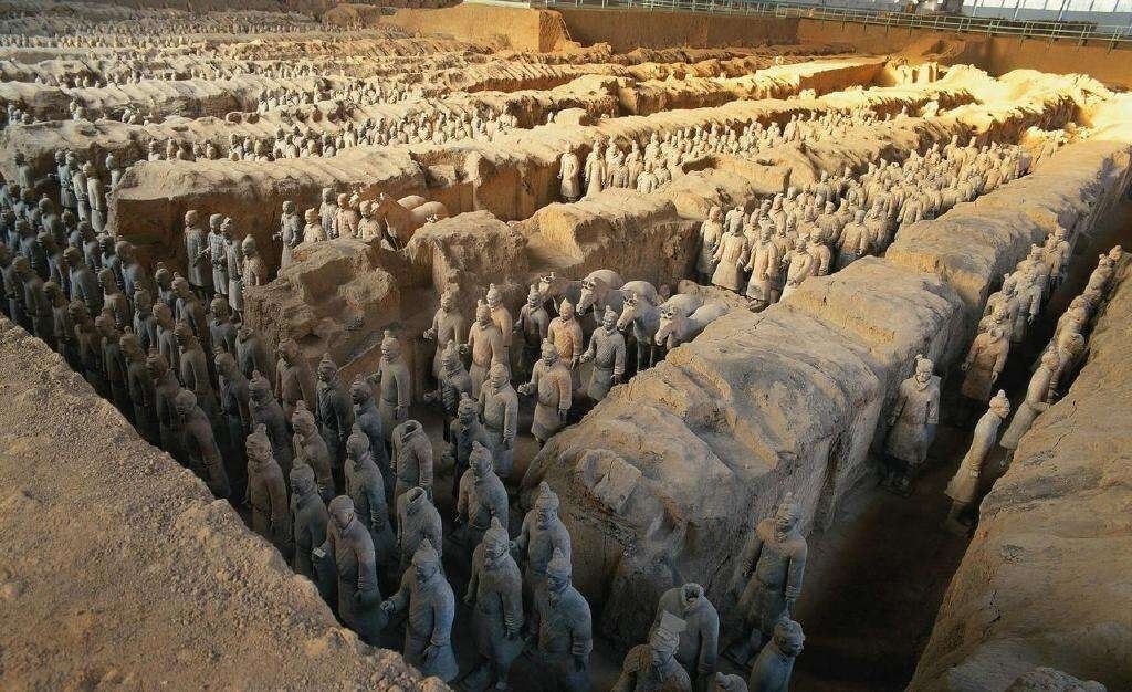 A large open area with numerous terracotta warrior statues arranged in rows and columns.