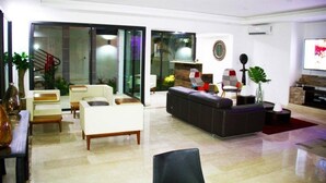 A modern living room with a sofa, chairs, and a fireplace. - Villa Malis T6 (Abidjan)