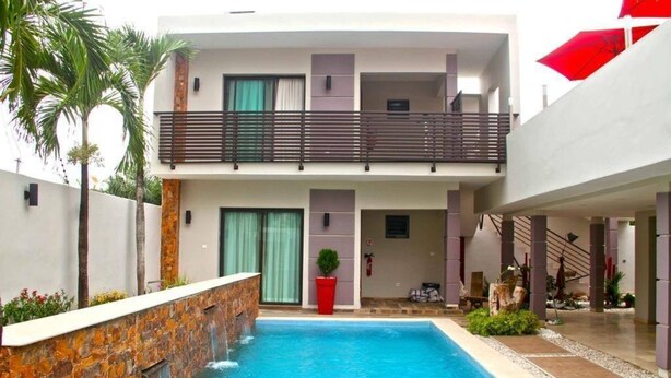 A modern two-story building with a swimming pool, a balcony, and a staircase leading to the upper floor. - Villa Malis T6 (Abidjan)