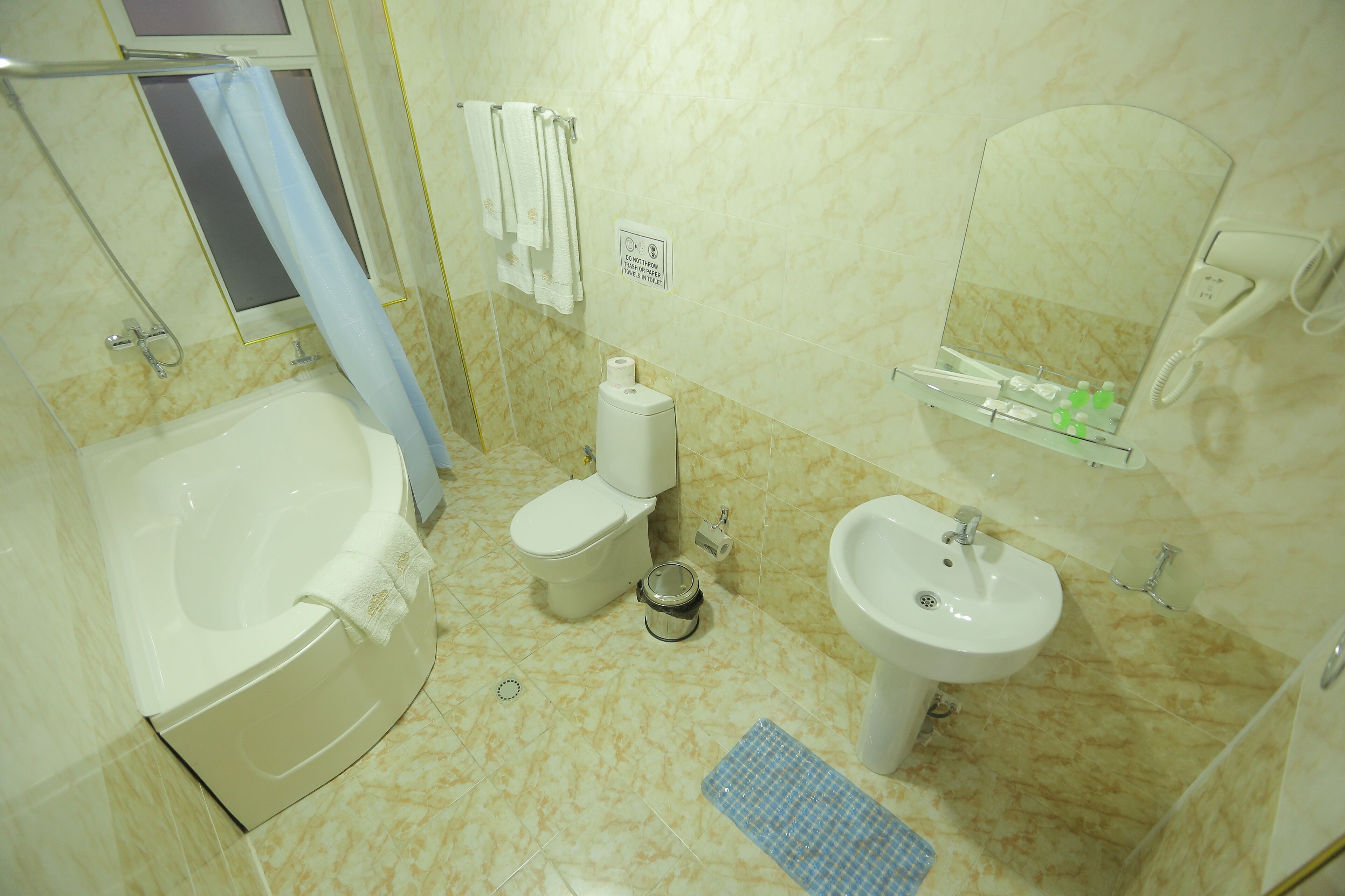 A bathroom with a bathtub, toilet, sink, and a mirror.
