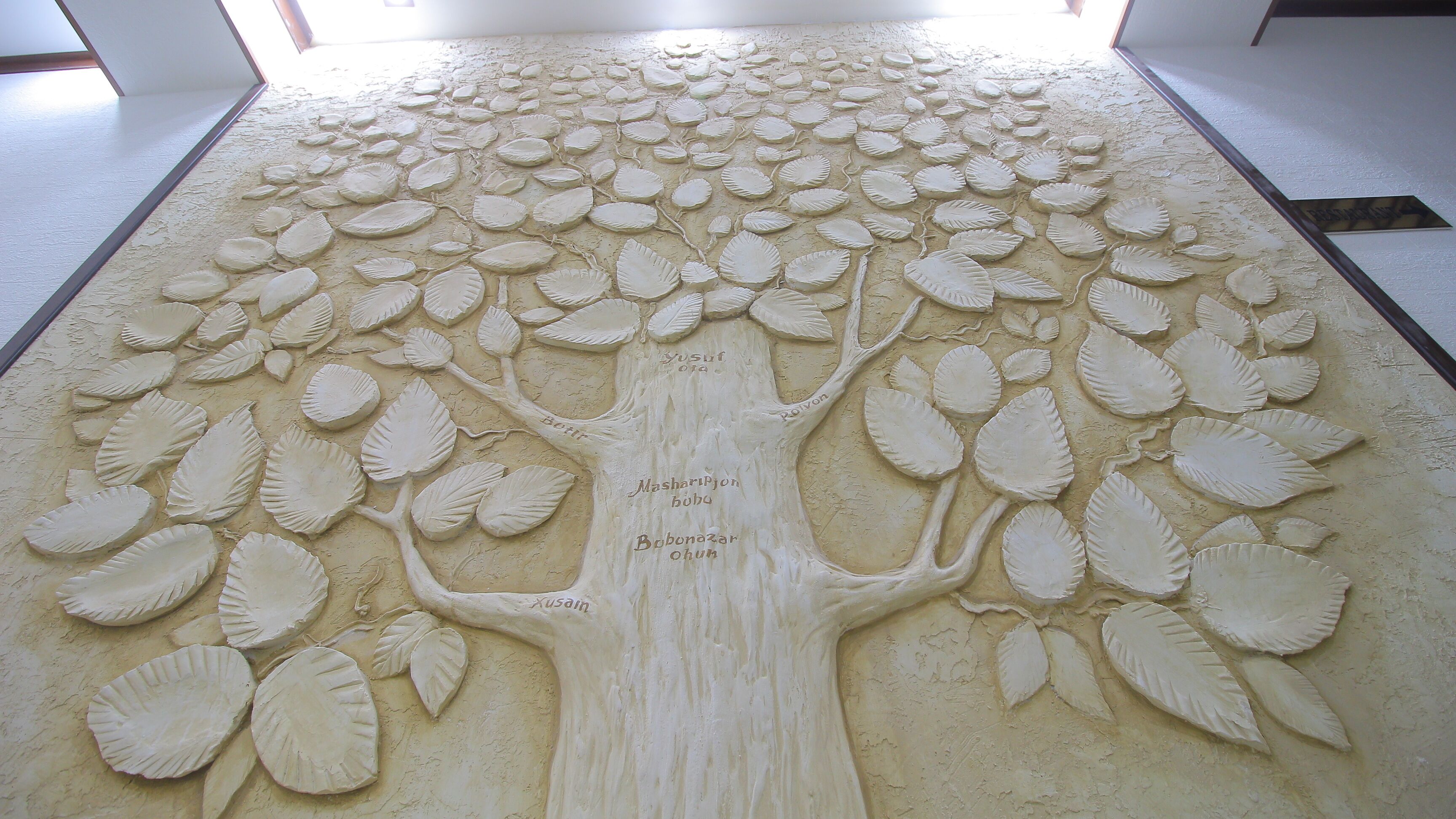 A detailed sand art of a tree with inscriptions.