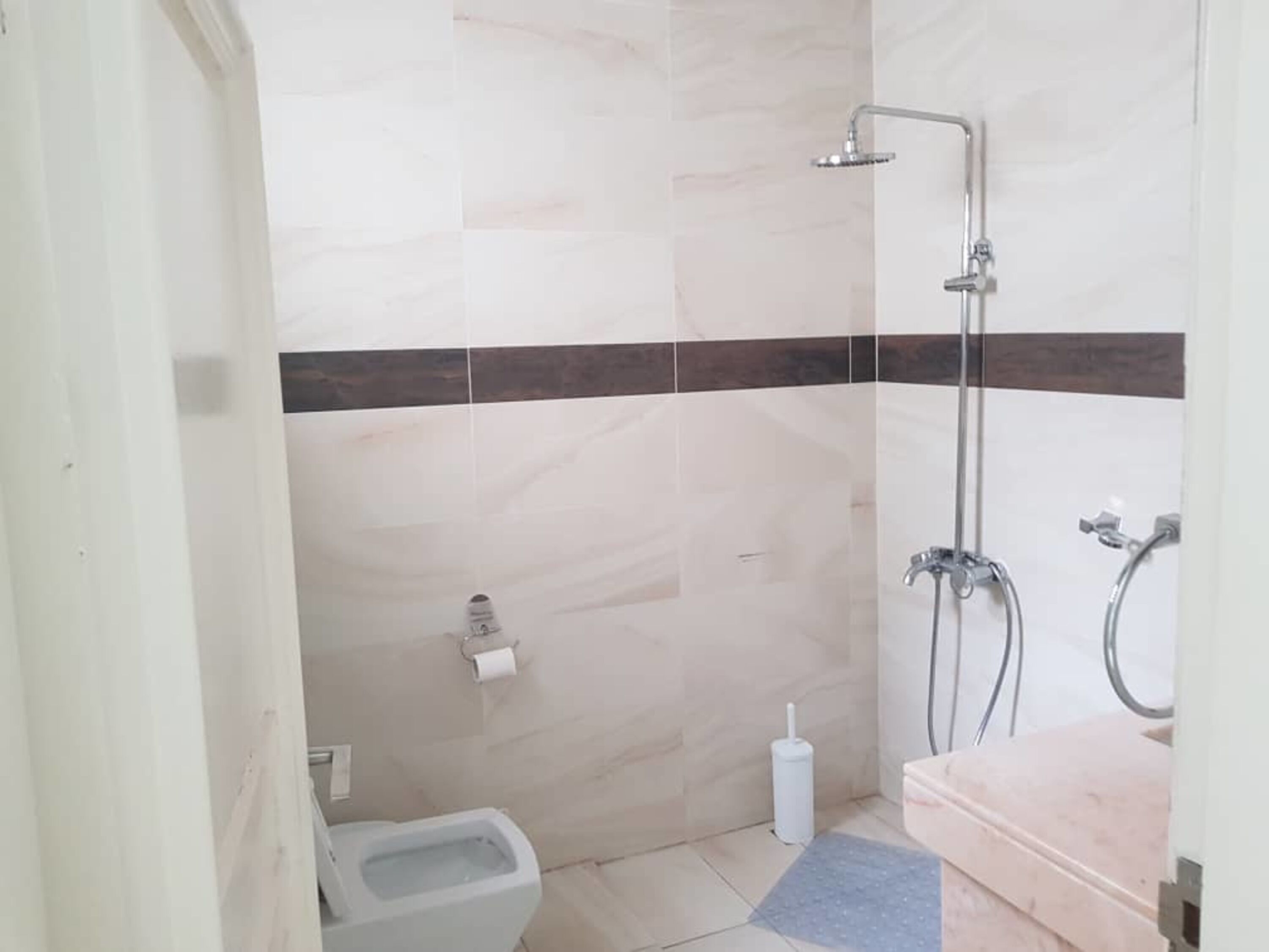 A small bathroom with a toilet, a bidet, a shower, and a sink.