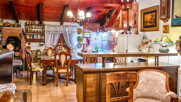 A rustic kitchen with wooden furniture, a brick fireplace, and various kitchen items. - Gorgeous and Spacious Apartment Equipped with Unique and Valuable Furniture  (Split)