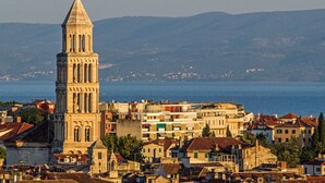 A coastal town with a prominent church tower, a sea view, and a mix of residential buildings. - Gorgeous and Spacious Apartment Equipped with Unique and Valuable Furniture  (Split)