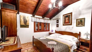 A bedroom with a wooden bed, a nightstand, a dresser, and a television. - Gorgeous and Spacious Apartment Equipped with Unique and Valuable Furniture  (Split)