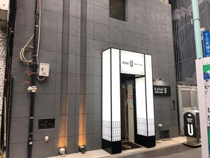 A hotel entrance with a modern design, featuring a prominent 'hotel U' sign above the door. - Hotel U (Tokyo)