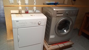 A washing machine and dryer side by side on a wooden platform. - Residence Mturquoise T1 (Abidjan)