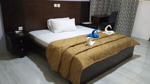 A hotel room with a bed, a nightstand, a desk, and a chair. - Residence Mturquoise T1 (Abidjan)