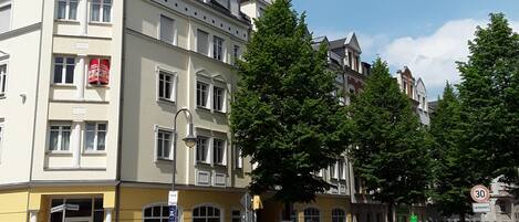 A multi-story building with a yellow facade, large windows, and a prominent entrance.
