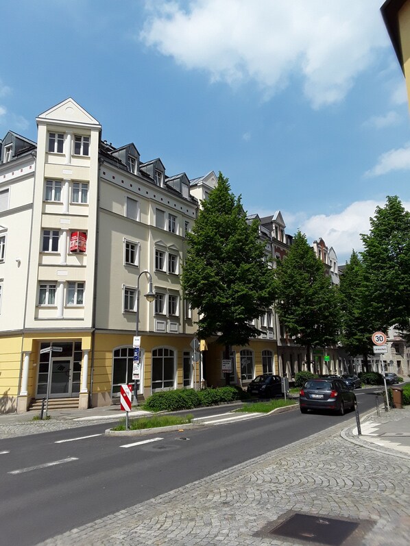 A multi-story building with a yellow facade, large windows, and a prominent entrance.