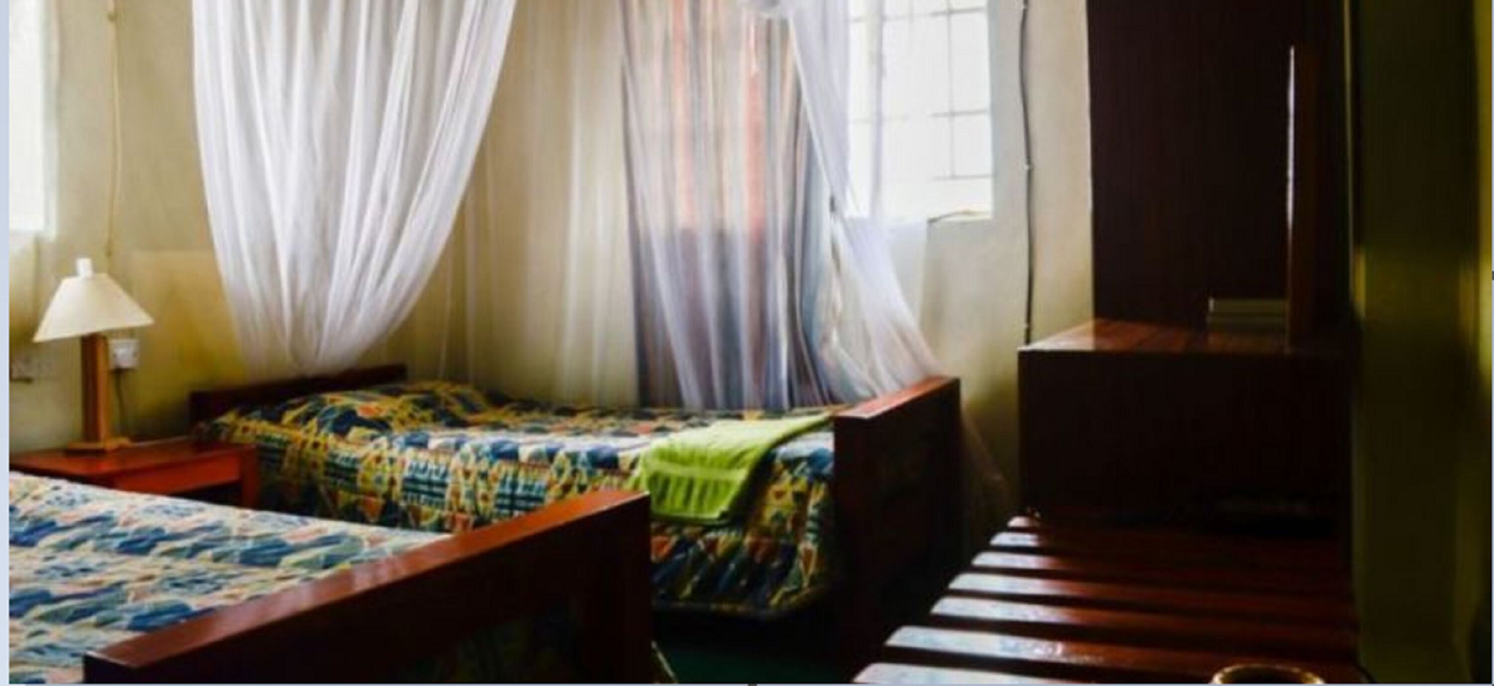 Een kamer met een bed, een bureau, een lamp en een televisie.