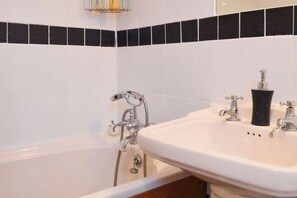 Tina con regadera, tina profunda, secadora de cabello, toallas 