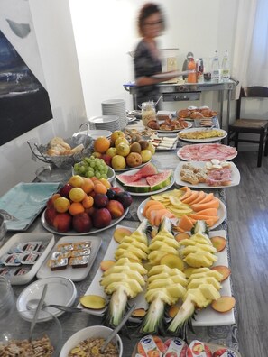 A buffet table with various fruits, pastries, and beverages. - Hotel Centrale (Trebaseleghe)