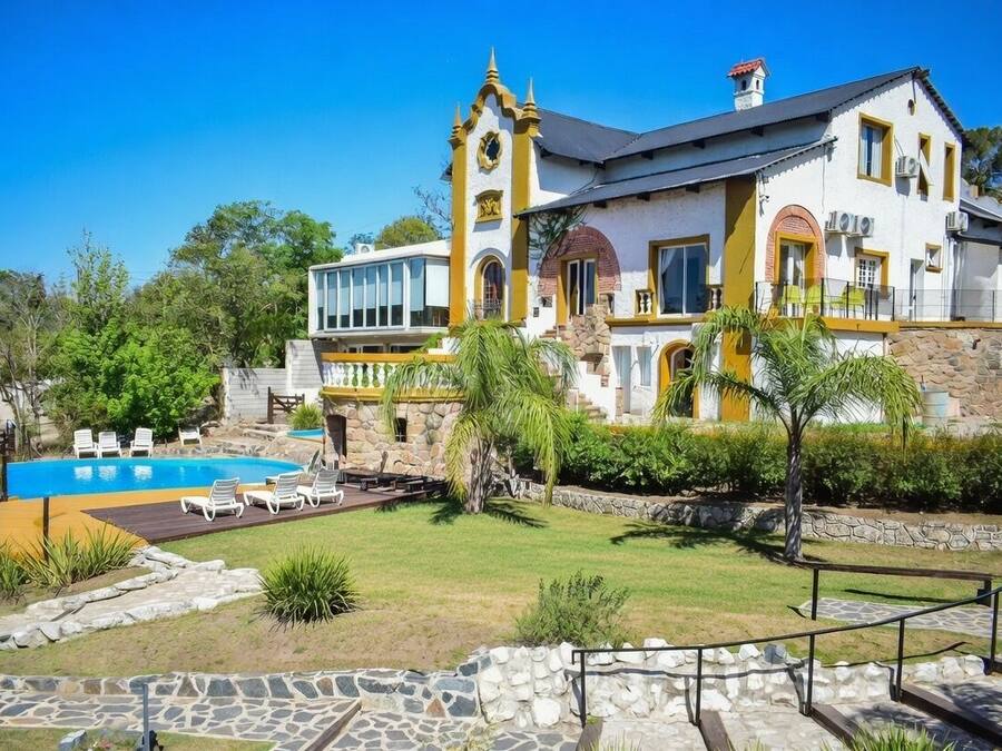 Una casa espaiosa amb piscina, escales de pedra i un jardí ben cuidat.