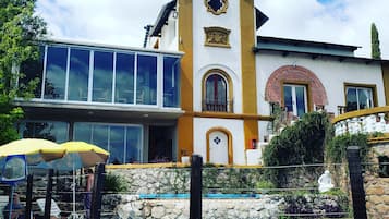 A building with a pool, a balcony, and a statue.