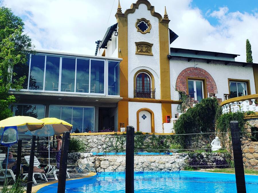 A building with a pool, a balcony, and a statue.