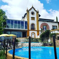 Un edificio con piscina, balcón y una estatua.