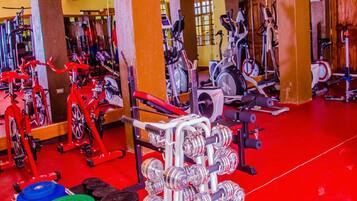 A gym with various exercise equipment, including treadmills, stationary bikes, and weight machines.