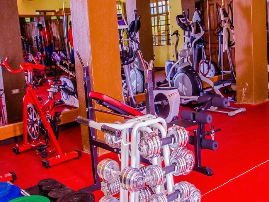 A gym with various exercise equipment, including treadmills, stationary bikes, and weight machines.