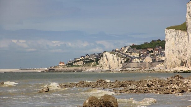 Une ville cÎtiÚre avec des bùtiments situés sur une falaise surplombant la mer.