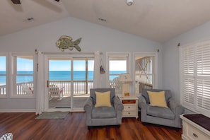 A room with a view of the ocean, a ceiling fan, and two armchairs. - Topsail State of Mind - 4BR Oceanfront Home; Elevator; Covered Porch (Surf City)