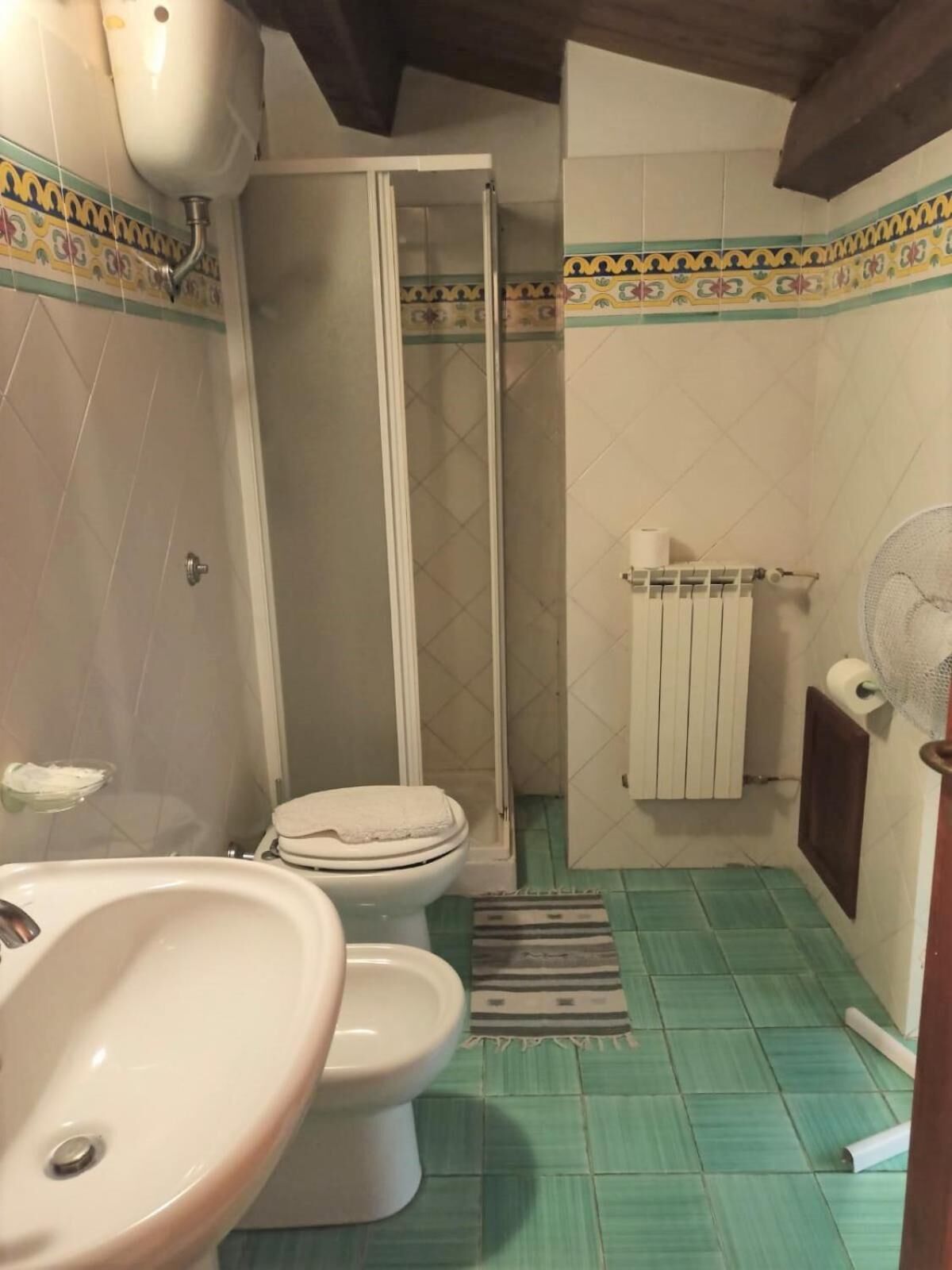 Une salle de bain avec douche, toilettes et lavabo.