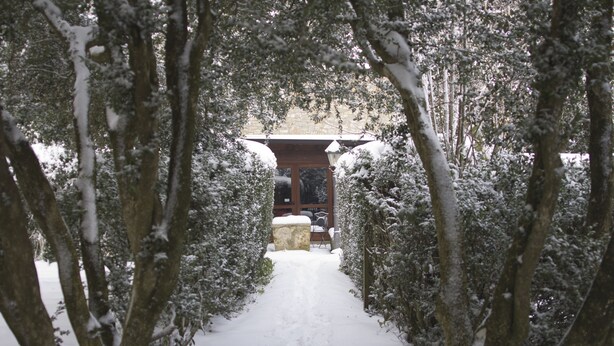 A snow-covered pathway leading to a building with a stone facade and wooden structure. - I Templari (Polizzi Generosa)