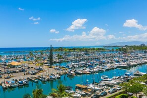 A marina with numerous boats docked, surrounded by palm trees and a clear blue sky. - Spacious One Bedroom Harbor View Condos at Ilikai Marina With Private Balcony (Honolulu)