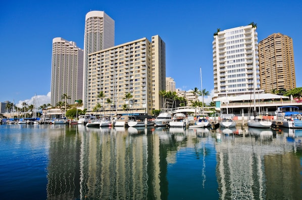 A marina with several boats docked, surrounded by high-rise buildings.