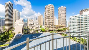 A cityscape with high-rise buildings, a clear sky, and a parking area. - Ilikai Marina Studio City View Condos with Fully Equipped Kitchens & Free Wifi (Honolulu)