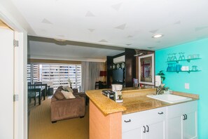 A compact living space with a kitchenette, a sofa, a dining area, and a view of the cityscape. - Ilikai Tower 1 Bedroom City View Condos with Private Lanai & Free Wifi! (Honolulu)