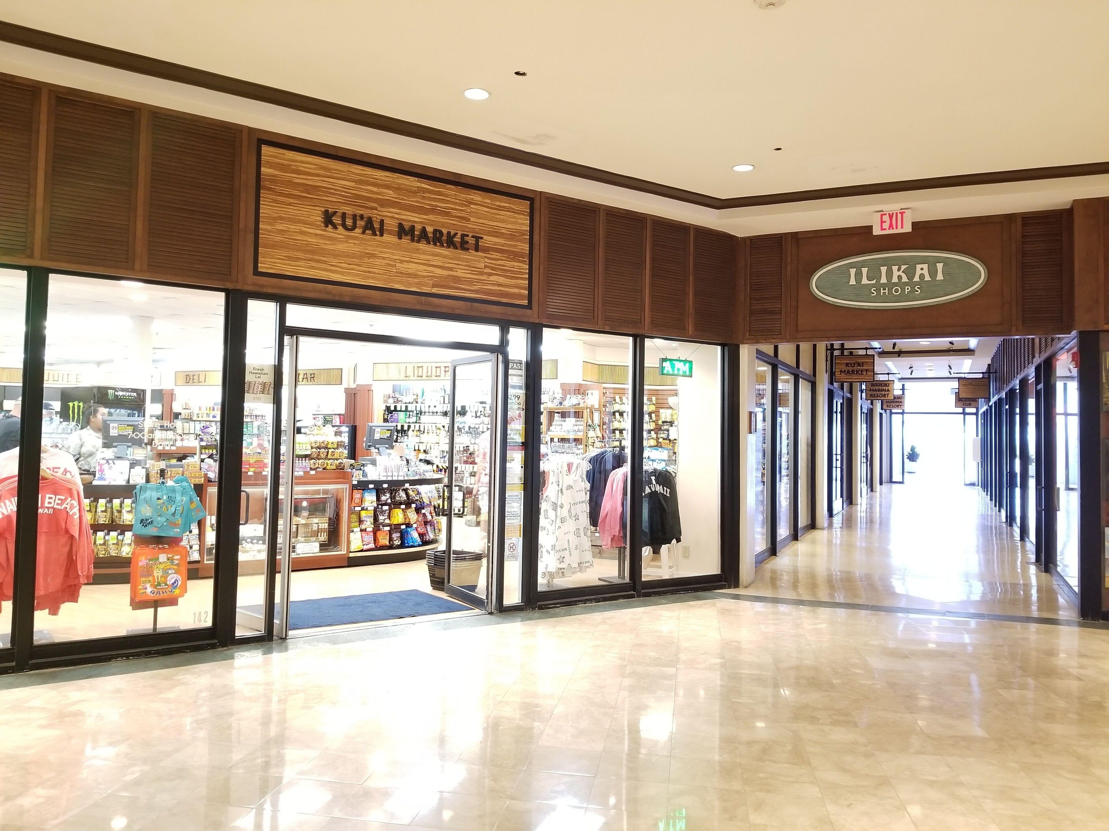 A shopping mall corridor with a 'KUAI MARKET' store and an 'ILKAI SHOPS' store.