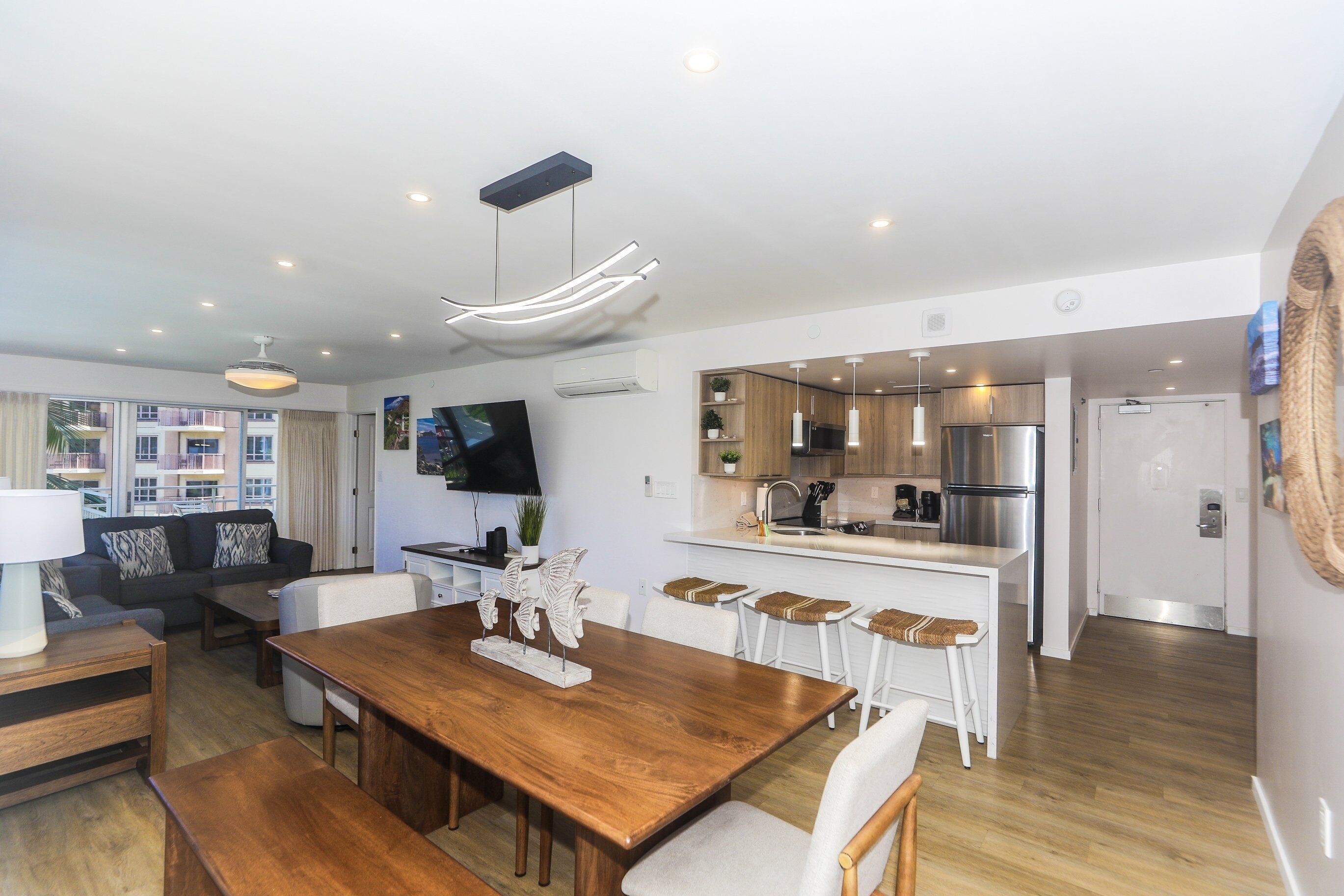 A modern apartment with a dining area, kitchen, and living room.