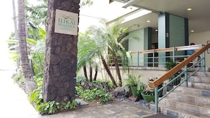 A stone pillar with a sign reading "ILIKAI MARINA" in a well-maintained outdoor area with palm trees and potted plants. - Ilikai Marina One Bedroom Harbor View Condos - Walk to Ala Moana Beach Park! (Honolulu)