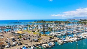 A marina with numerous boats docked, surrounded by palm trees and a clear blue sky. - Ilikai Tower 943 Condo - Walk to the Beach, Shops & Restaurants! by RedAwning (Honolulu)
