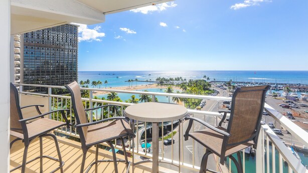A balcony with a view of the beach, pool, and ocean. - Ilikai Tower 943 Condo - Walk to the Beach, Shops & Restaurants! by RedAwning (Honolulu)