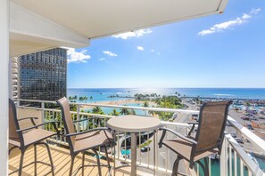 Un balcon avec vue sur la plage, la piscine et l’océan.