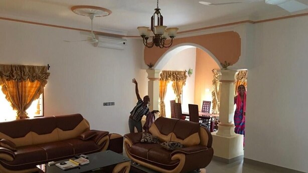 Ein Wohnzimmer mit zwei Ledersofas, einem Couchtisch und einer Chandelier.