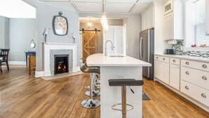 Une cuisine moderne dotée d’un îlot central, de meubles blancs et d’un plancher en bois.
