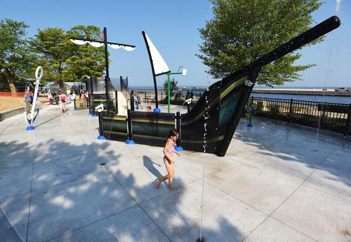 A water play area with a large ship sculpture and a fountain.